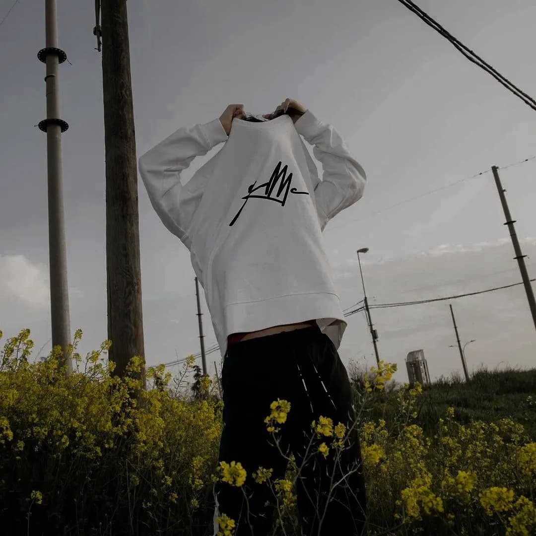 a sweater pulled over a face in a field of yellow flowers