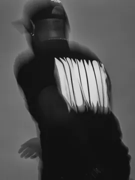 A black tee with a large white back print, shot in motion